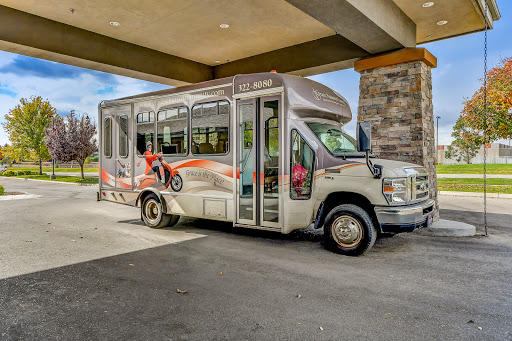 A colorful shuttle bus parked under a canopy, ready for passengers.