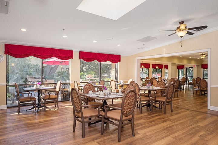 A bright and inviting dining area with wooden flooring and red accents.