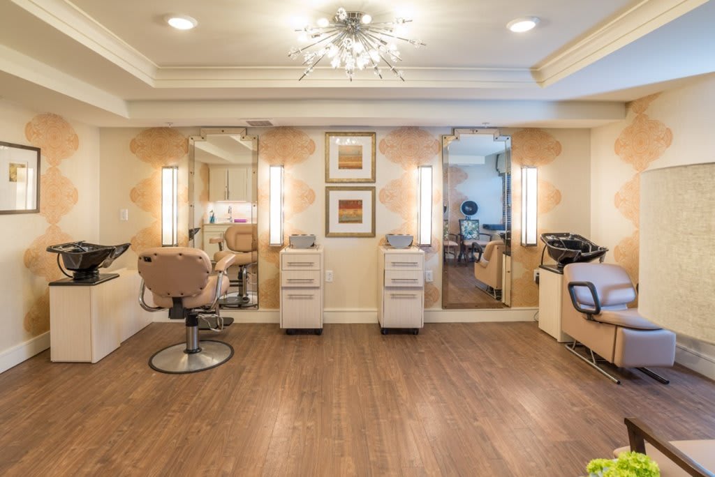 A modern beauty salon interior with chairs and mirrors.