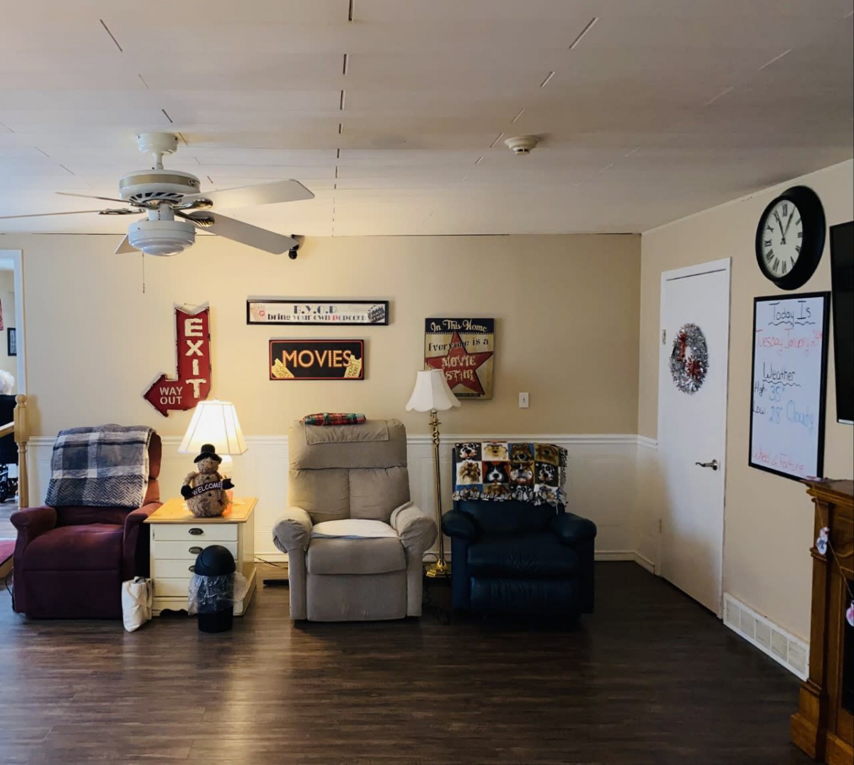 A cozy living room with armchairs and wall decorations.