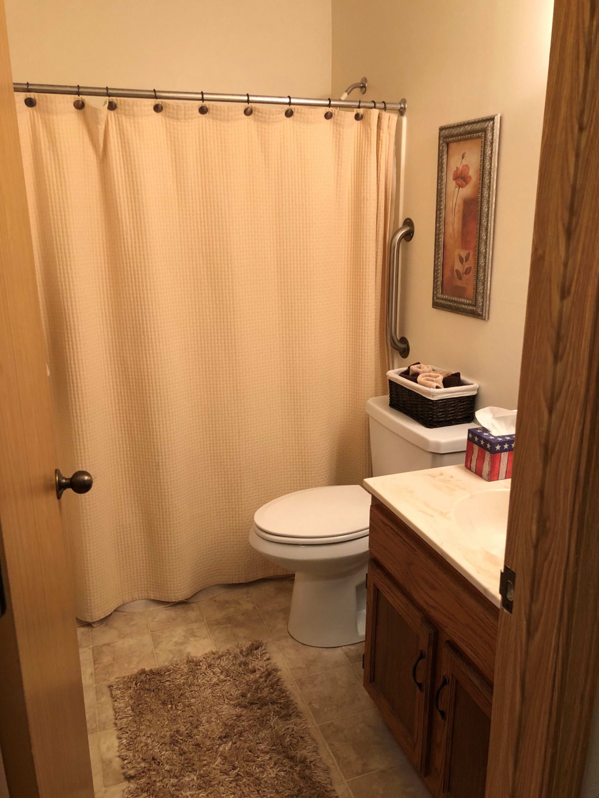 A small bathroom with a shower curtain, toilet, and sink.