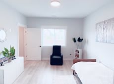 A minimalist bedroom with modern decor and white walls.