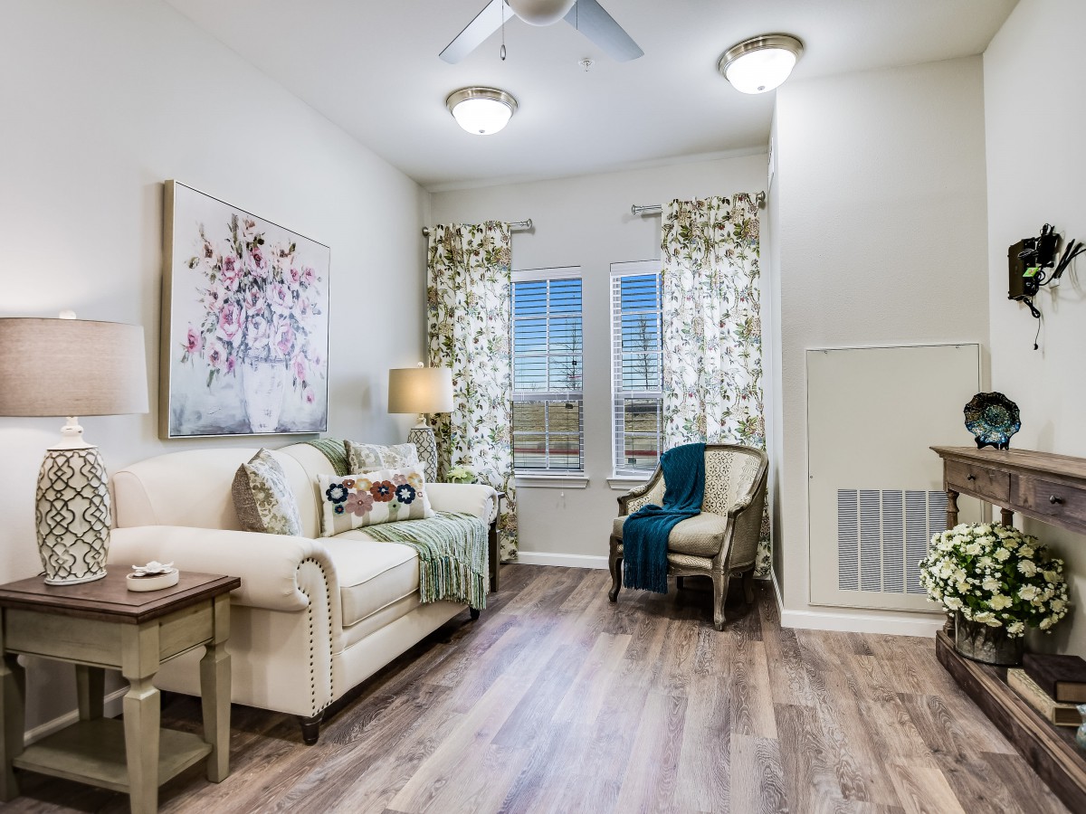 A cozy living room featuring a comfortable sofa, armchair, and stylish decor with large windows letting in natural light.