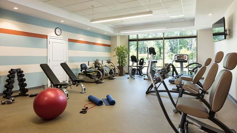 A modern gym with various exercise equipment and workout spaces.
