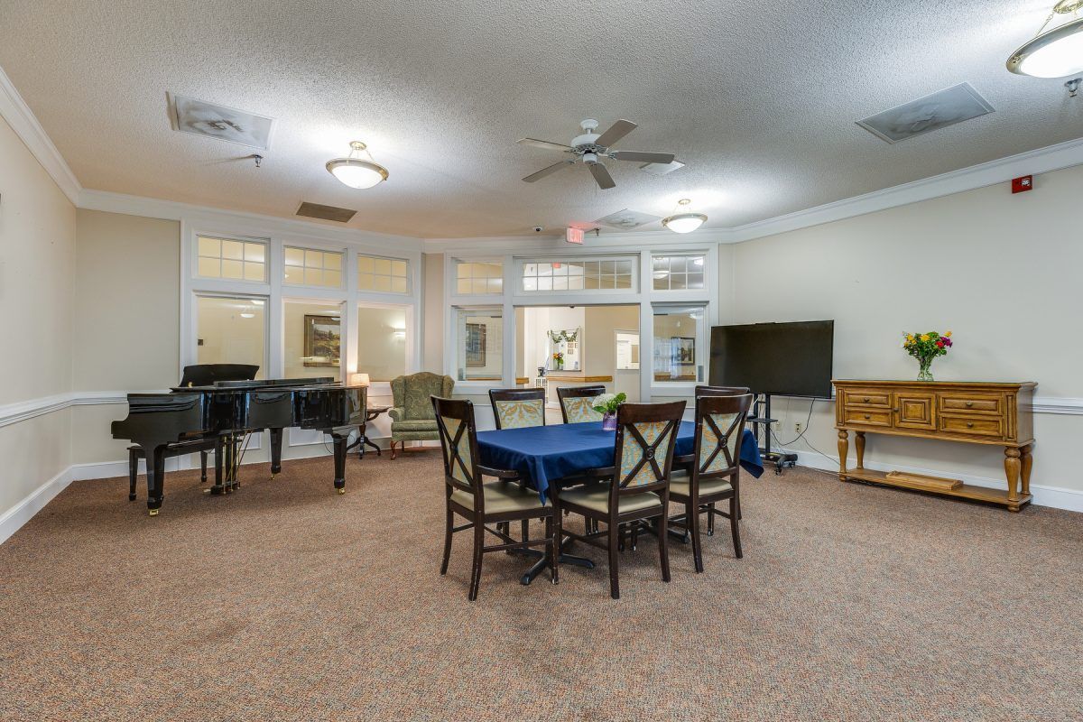 A cozy living room with a dining area, featuring a piano, TV, and comfortable seating.