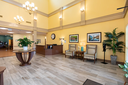 A bright and inviting hotel lobby featuring elegant furniture and decorative plants.