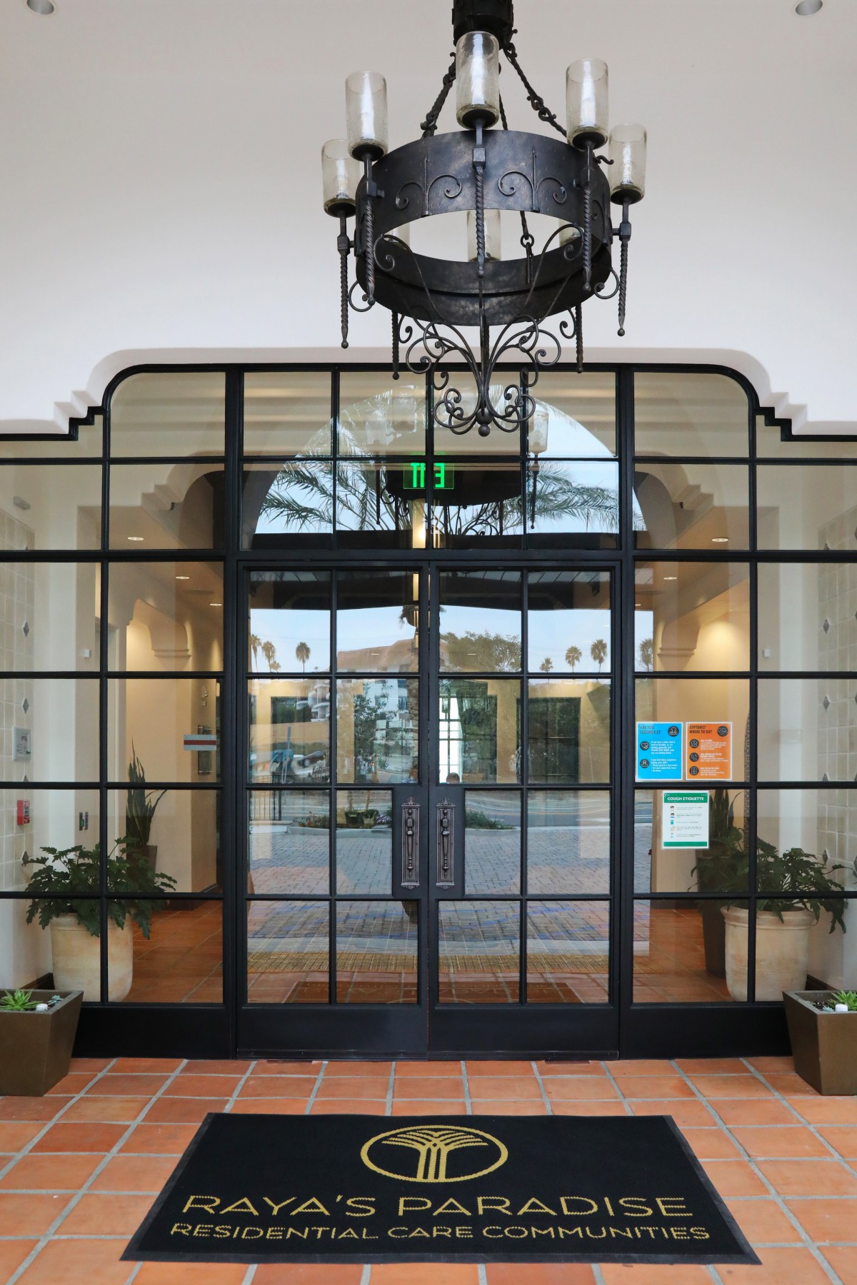 A stylish indoor entrance featuring glass doors and a decorative chandelier.