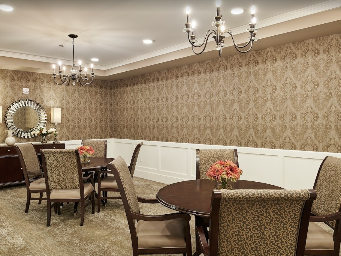 Elegant dining room with chandeliers and patterned wallpaper.