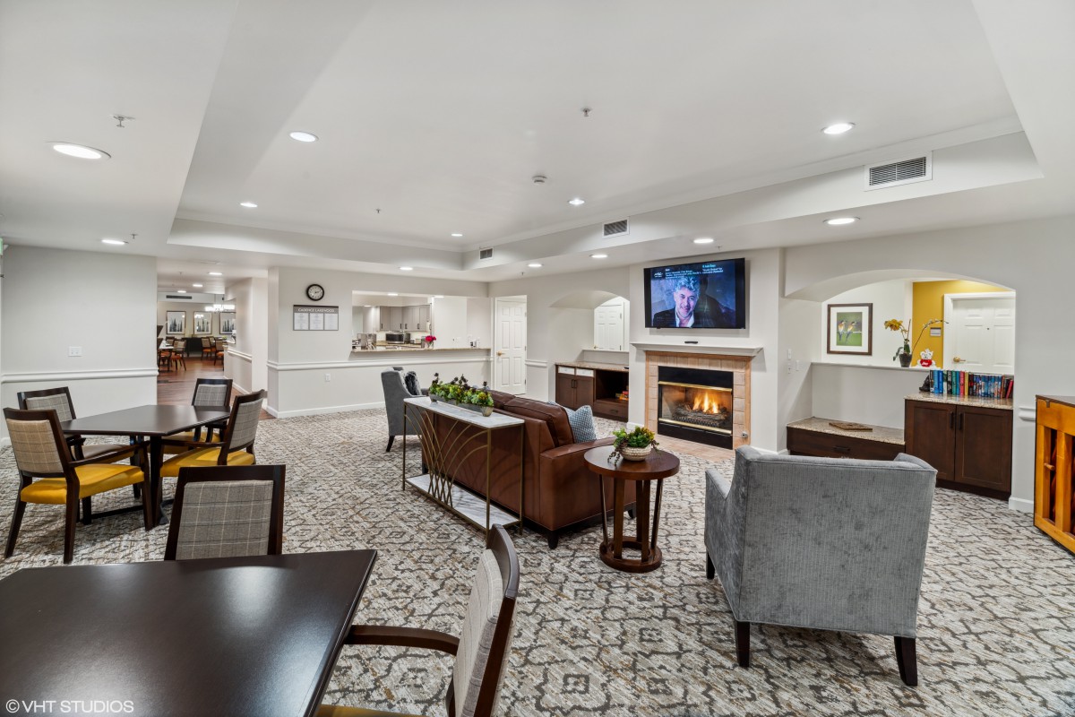 A cozy and modern living room with a seating area, fireplace, and television.