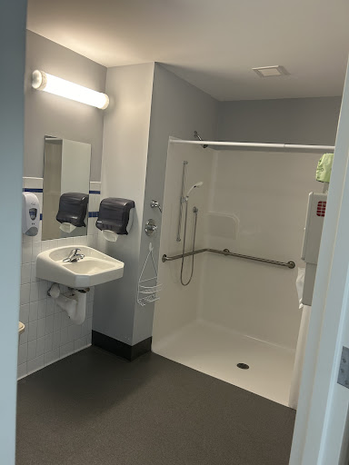 A clean and modern bathroom featuring a shower and sink, designed for accessibility.