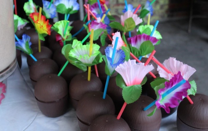 Decorative chocolate-covered apples adorned with colorful flower toppers.