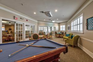 A modern game room featuring a billiards table and comfortable seating.