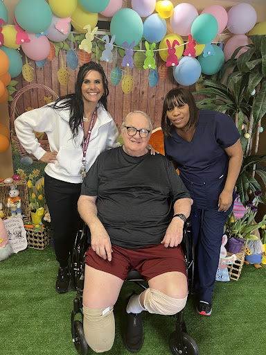 A joyful moment captured with caregivers and a resident during a festive celebration.