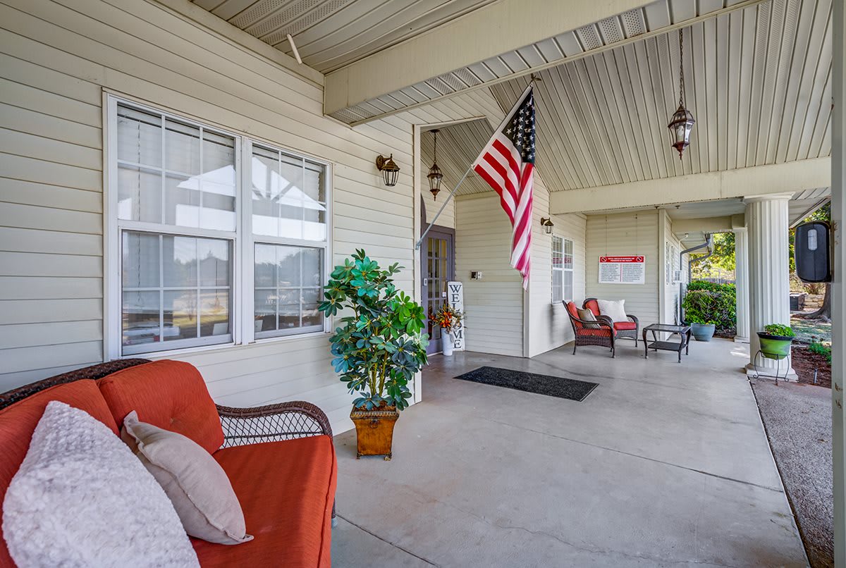 A cozy porch with comfortable seating and an American flag.