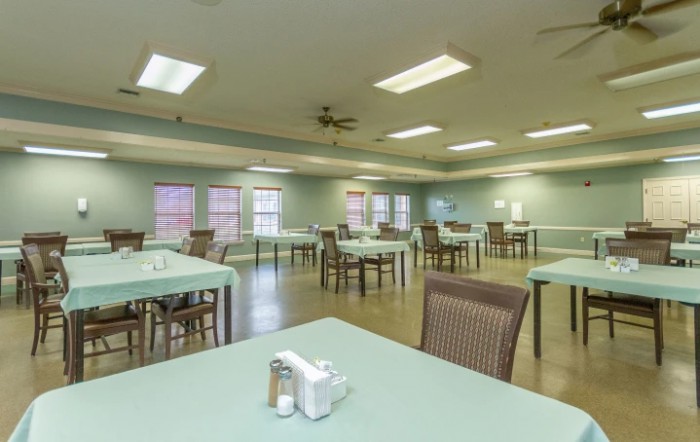 An empty dining room with neatly arranged tables and chairs.