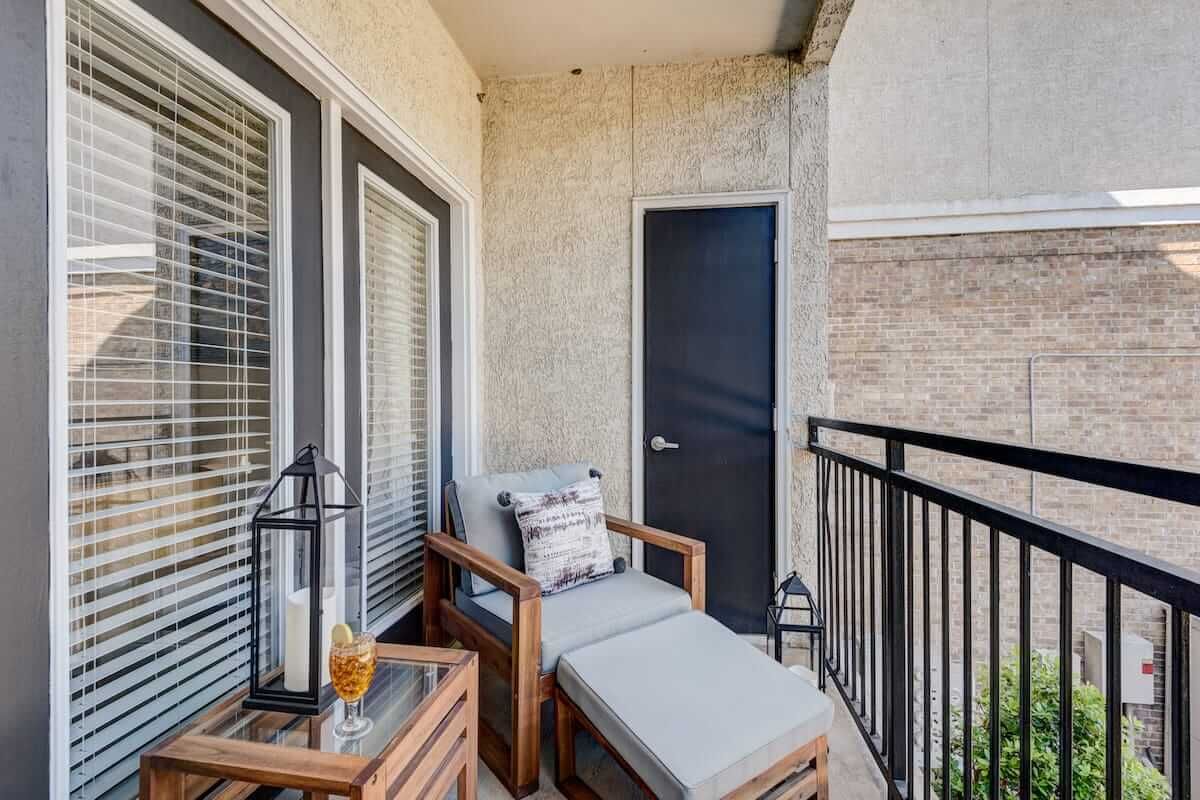A cozy balcony featuring comfortable seating and decorative elements.