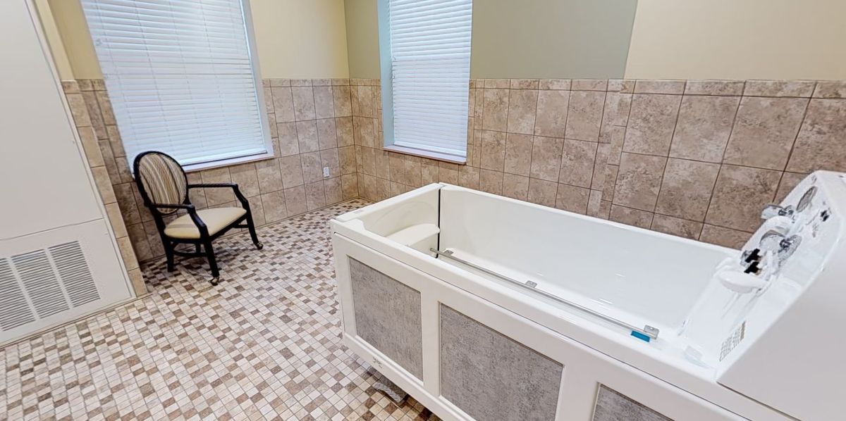 A spacious bathroom with a modern bathtub and tiled flooring.