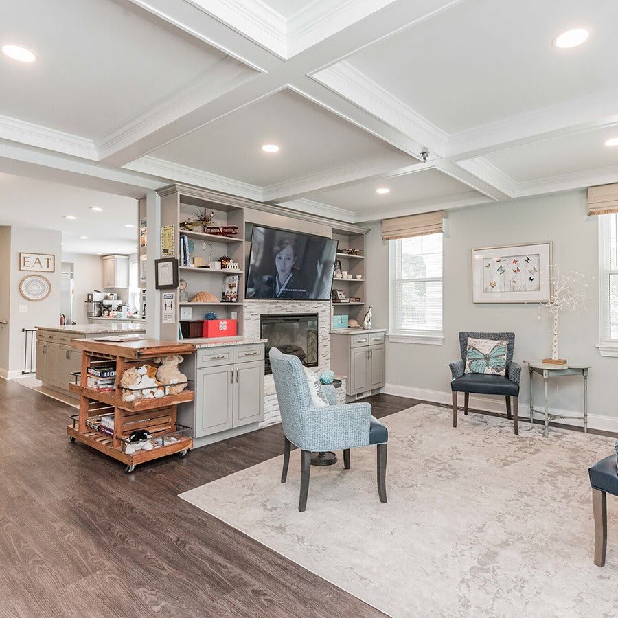 A stylish living room featuring a coffered ceiling, fireplace, and modern furniture.