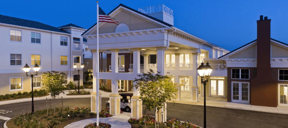 A beautifully lit building entrance with a flagpole at night.