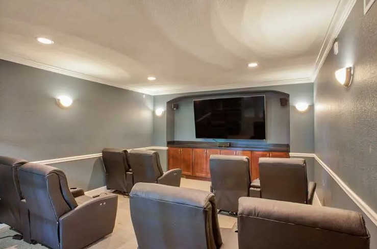 A cozy home theater setup with comfortable recliner seating in front of a large screen.
