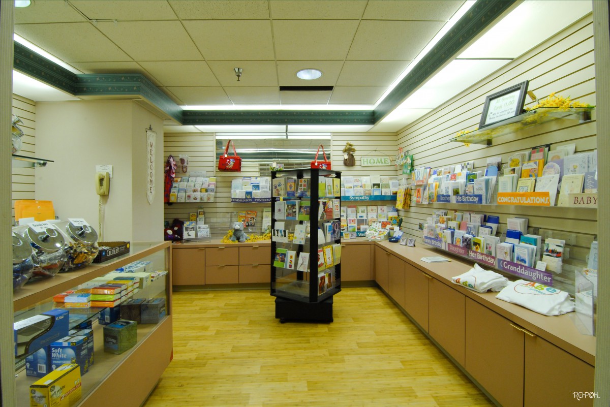 Interior view of a pharmacy with shelves stocked with medical supplies and products.