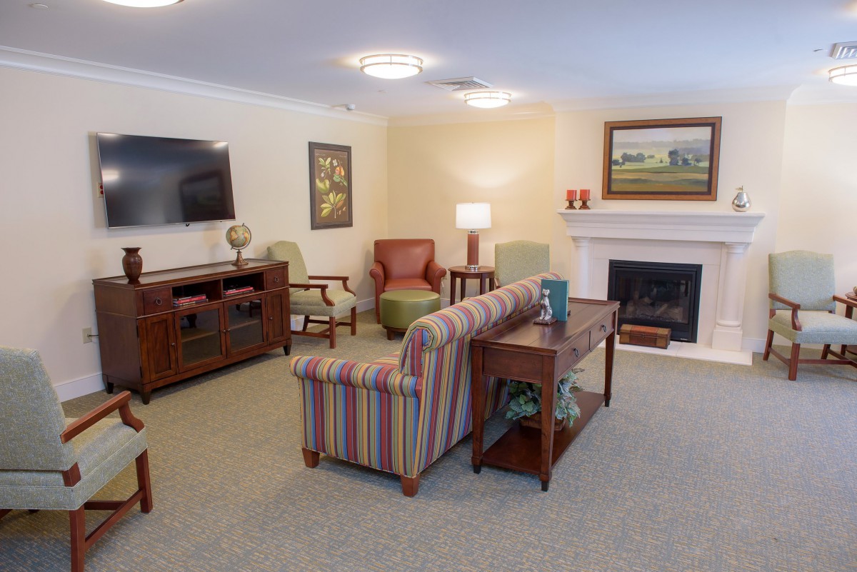 A cozy living room with comfortable seating, fireplace, and a television.