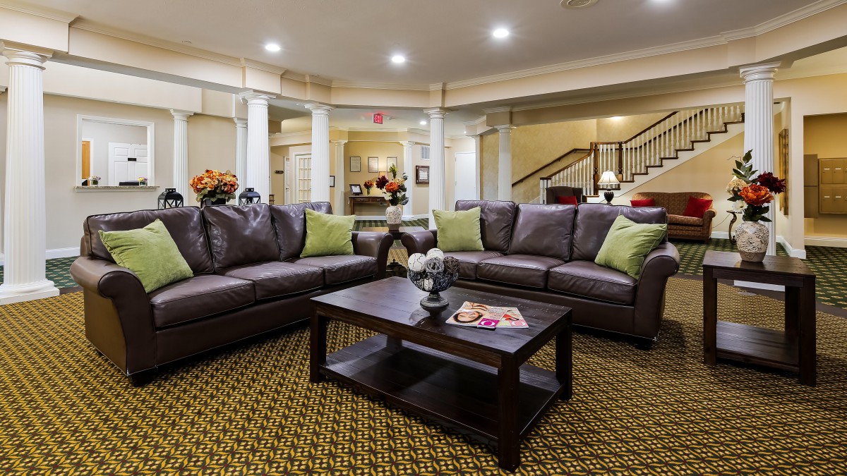 A cozy living room with dark sofas, a wooden coffee table, and decorative pillows.