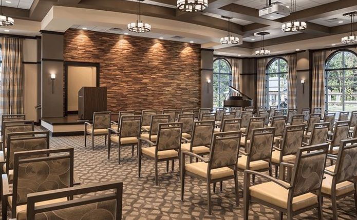 An empty conference room with neatly arranged chairs and a podium at the front.
