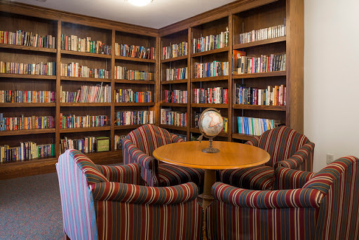 A cozy library corner featuring bookshelves filled with books and a comfortable seating area.