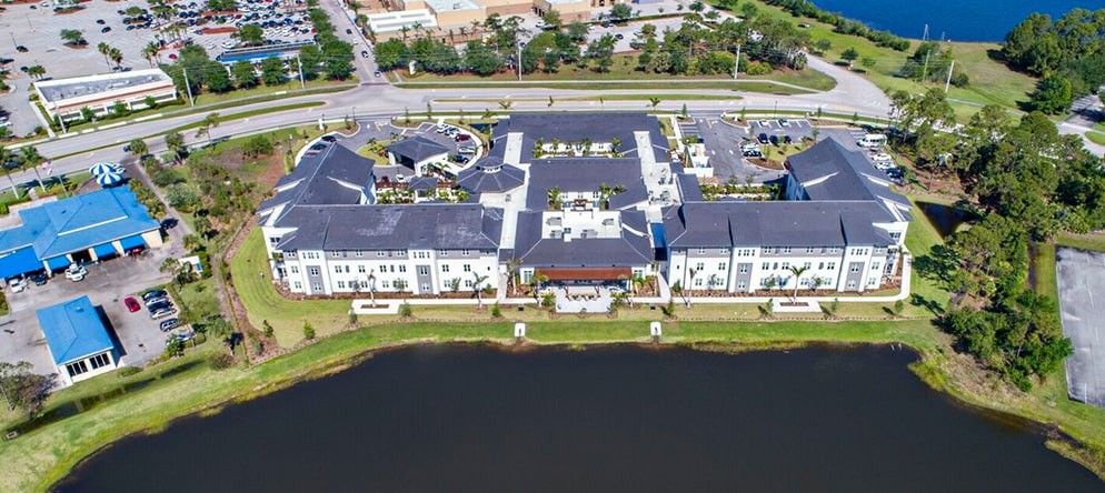 Aerial view of a large building complex situated by a body of water.