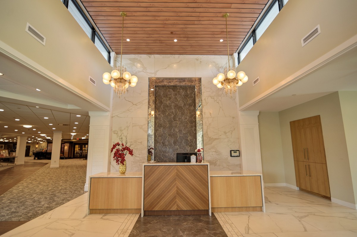 A modern reception area featuring a wooden desk and stylish lighting.