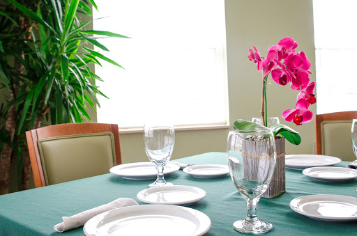 A beautifully arranged dining table featuring elegant dinnerware and a vibrant floral centerpiece.