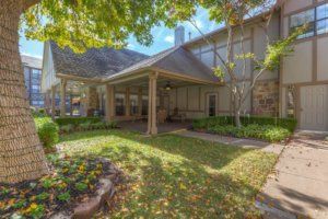 A charming house with a well-maintained garden and shaded porch.
