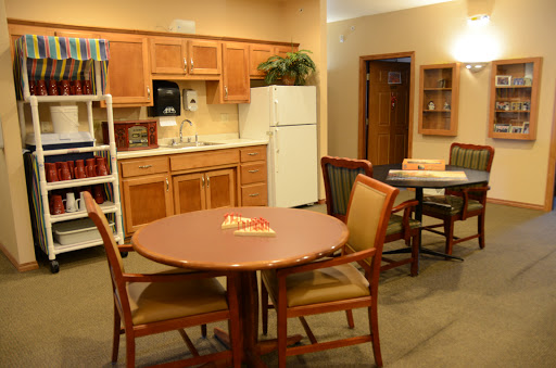 A cozy kitchen and dining area featuring a wooden table and chairs, with modern appliances in the background.