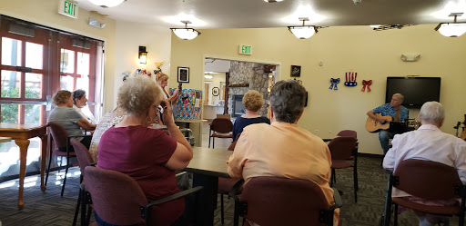 A gathering of seniors listening to a presentation at a community center.