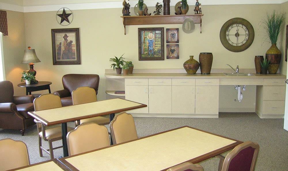 A cozy dining area with tables, chairs, wall decor, and ornamental vases.