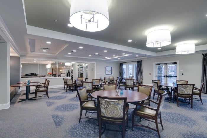 A well-lit dining area with arranged tables and chairs, showcasing elegant interior design.