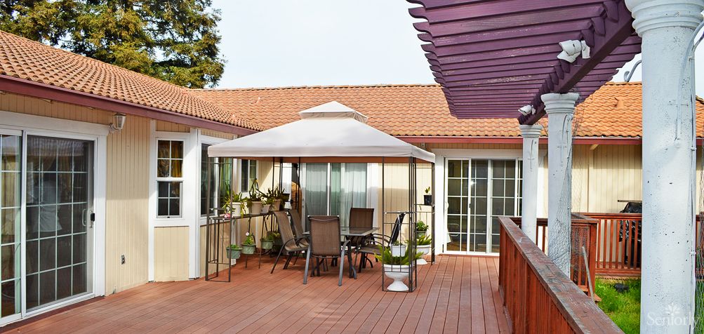 A cozy patio setup with a gazebo and outdoor furniture on a wooden deck.