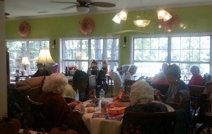 A group of seniors gathered in a dining room setting.