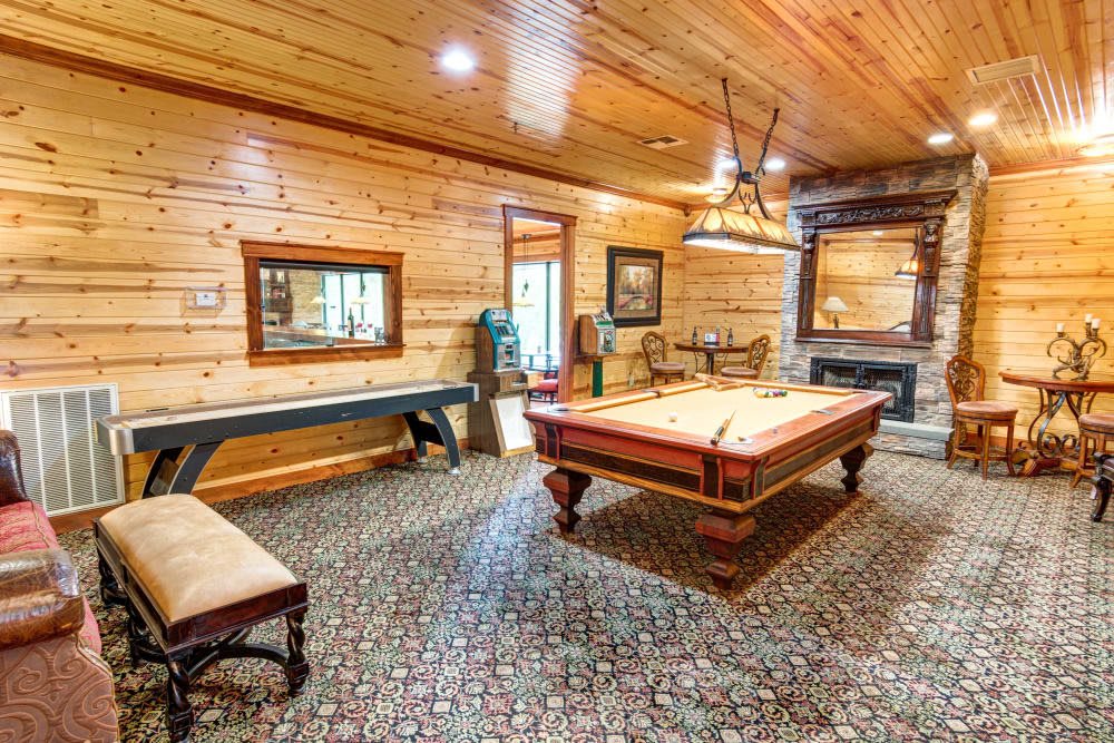 A cozy game room featuring a billiard table and wooden interior design.