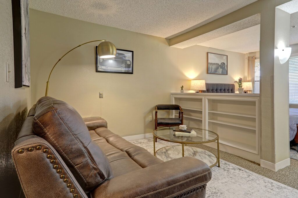 A cozy living room featuring a comfortable sofa, modern lamp, and stylish decor.