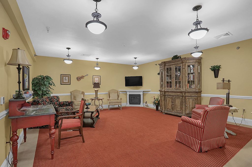A cozy living room with comfortable seating, a large cabinet, and a television.