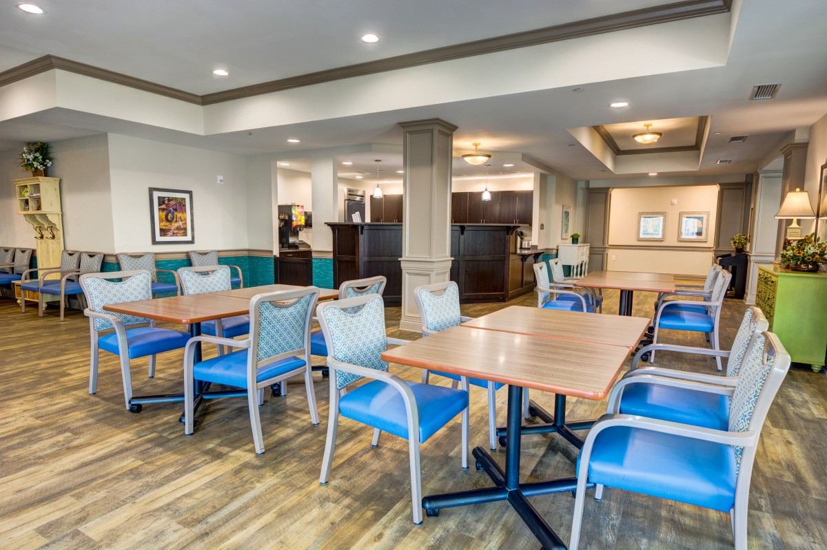 A modern dining area with neatly arranged tables and chairs, featuring contemporary interior design.