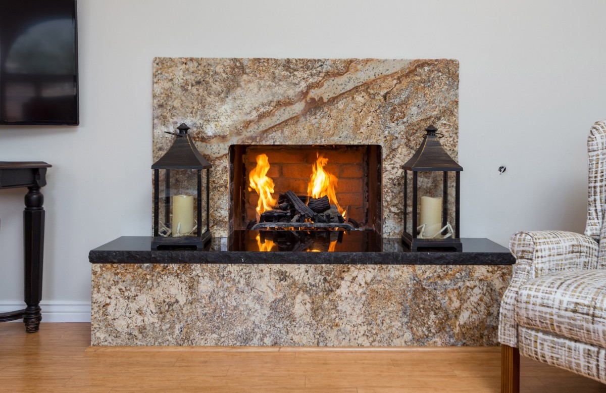 A warm and inviting fireplace with decorative lanterns on the mantel.