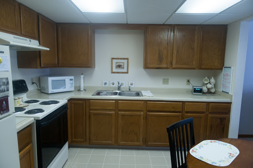 A well-organized kitchen featuring wooden cabinets, a microwave, and a dining area.