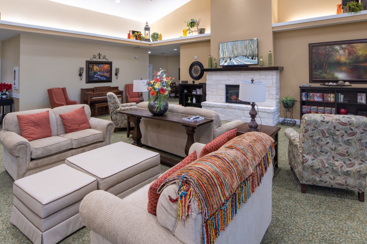 A cozy living room features comfortable sofas, a fireplace, and decorative elements.