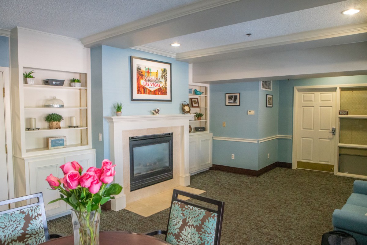 A cozy living room with a fireplace, artwork, and floral decor.