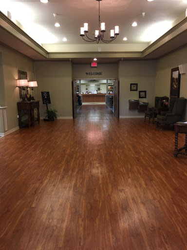 A spacious and well-lit lobby with wooden flooring, elegant furniture, and a welcoming atmosphere.