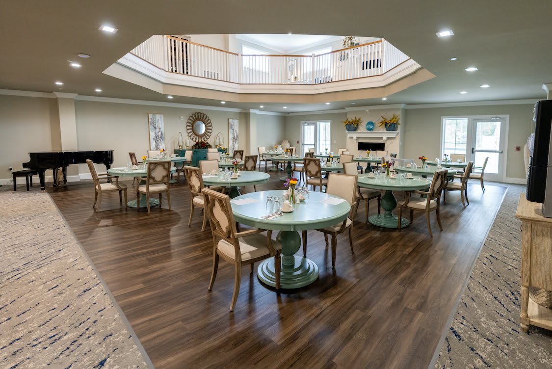 A modern dining area with round tables and elegant chairs on wooden flooring.