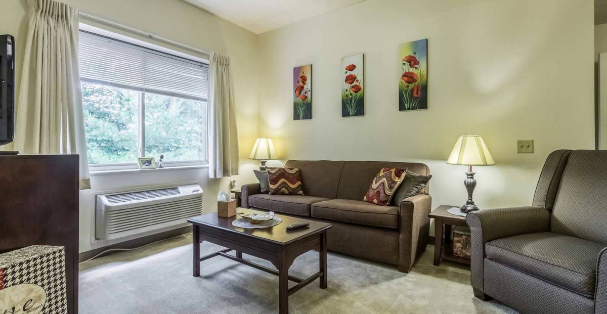 A cozy living room with a sofa, coffee table, and wall art.